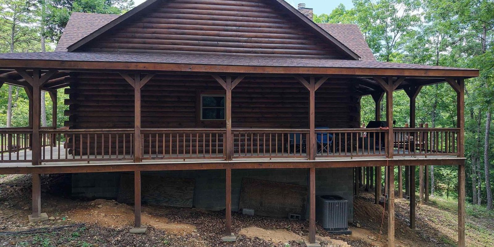 Wraparound porch of Sugar Creek Cabin, raised on posts above the creek bank