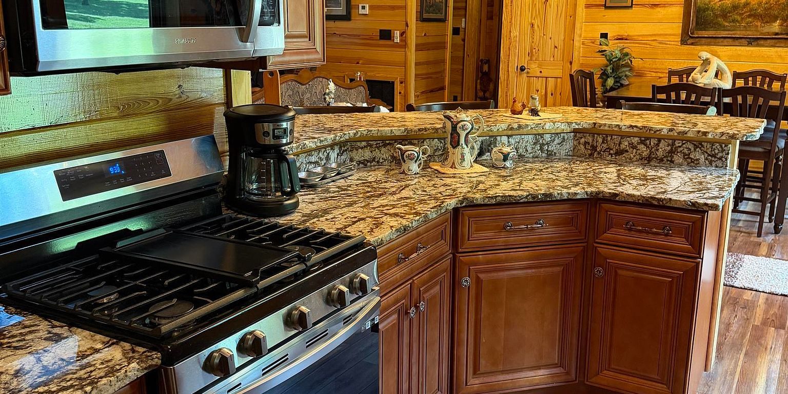 Gas range and granite peninsula in the Sugar Creek Cabin kitchen