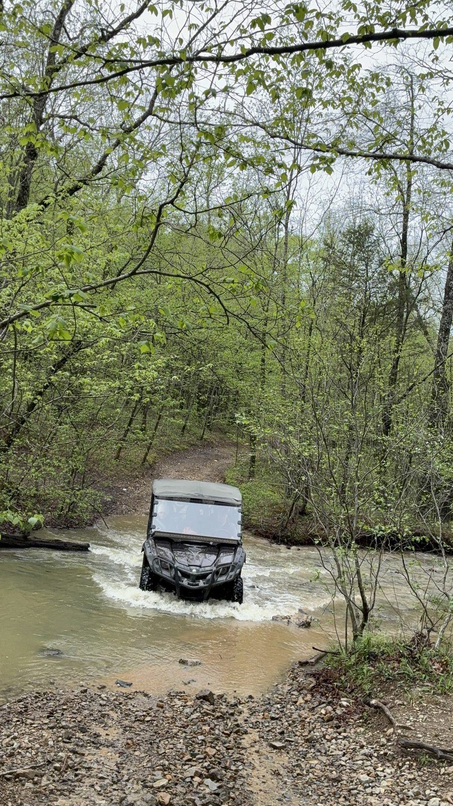 The rental Yamaha Viking VI crossing a creek on a forest trail near Arborium Cabins